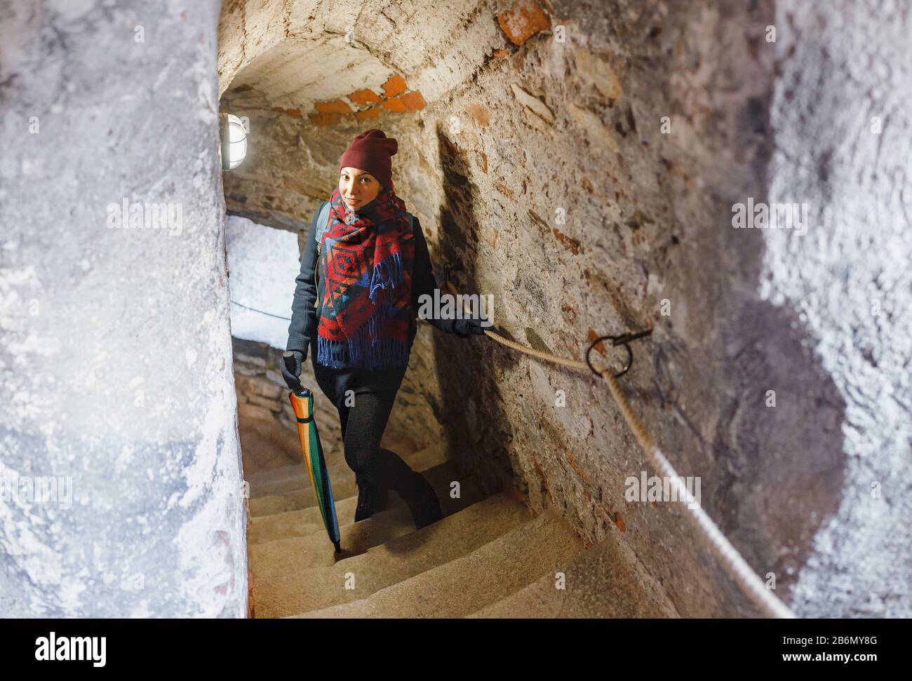 Girl tourist exploring the dungeon in castle Stock Photo