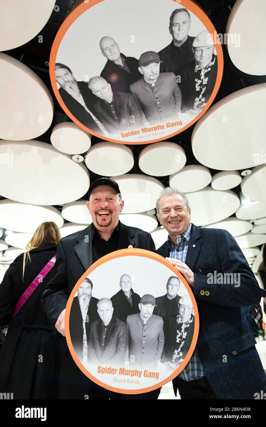 Munich, Germany. 11th Mar, 2020. Barny Murphy (l) and Günther Sigl from the band Spider Murphy Gang are standing in the Stachus Passages under a ceiling circle in the Sky of Fame with a photo of their band. In the Sky of Fame, at the ceiling circles of the Stachus Passages, there are pictures of Munich personalities. Murphy, Sigl unveiled their picture on 11.03.2020. Credit: Tobias Hase/dpa/Alamy Live News Stock Photo