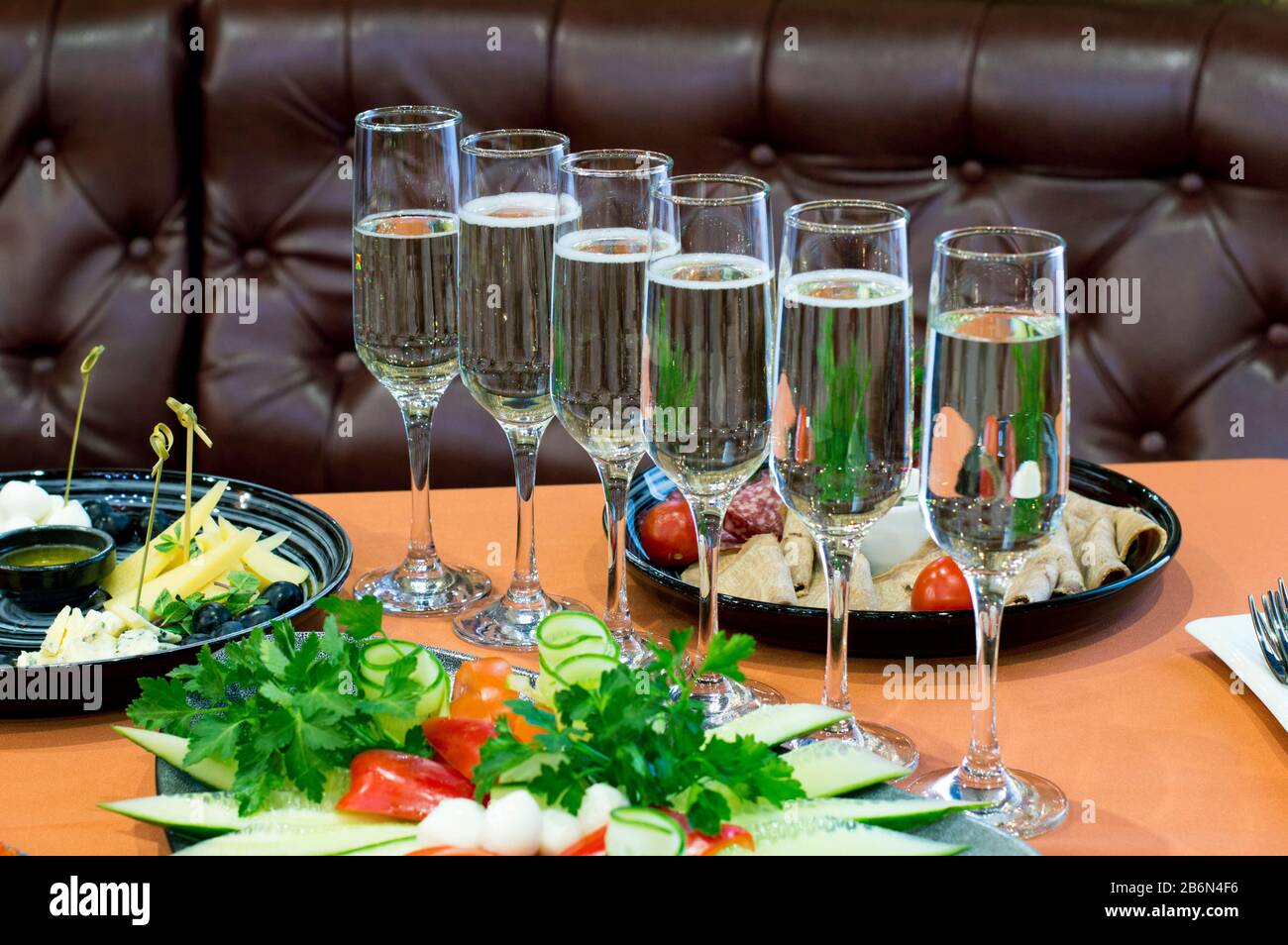 Glasses for champagne, filled and empty, stand on the table and wait for their owners. Stock Photo