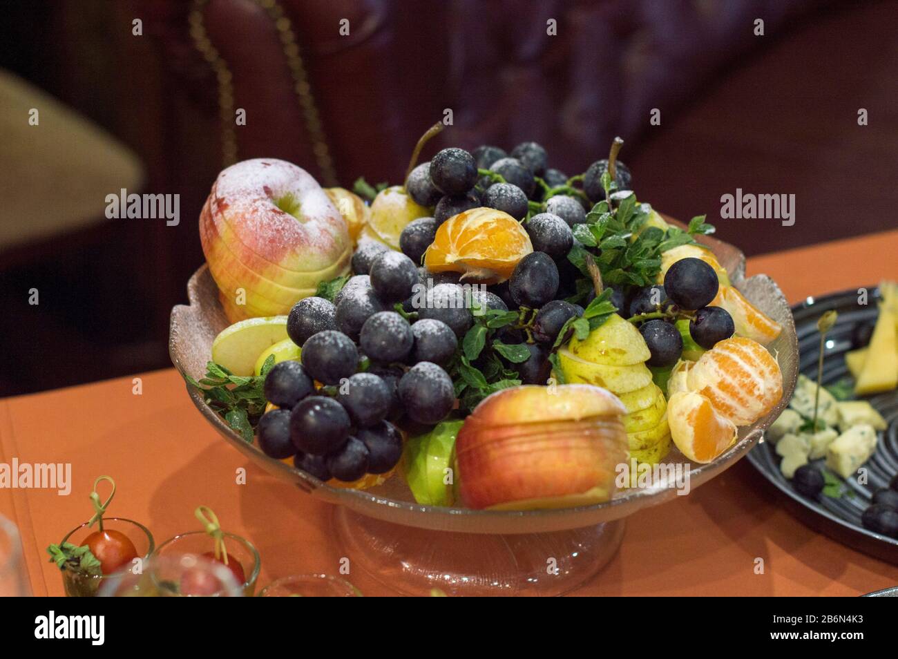 Vase with fruits on the table. Sliced and cooked for dinner. Stock Photo