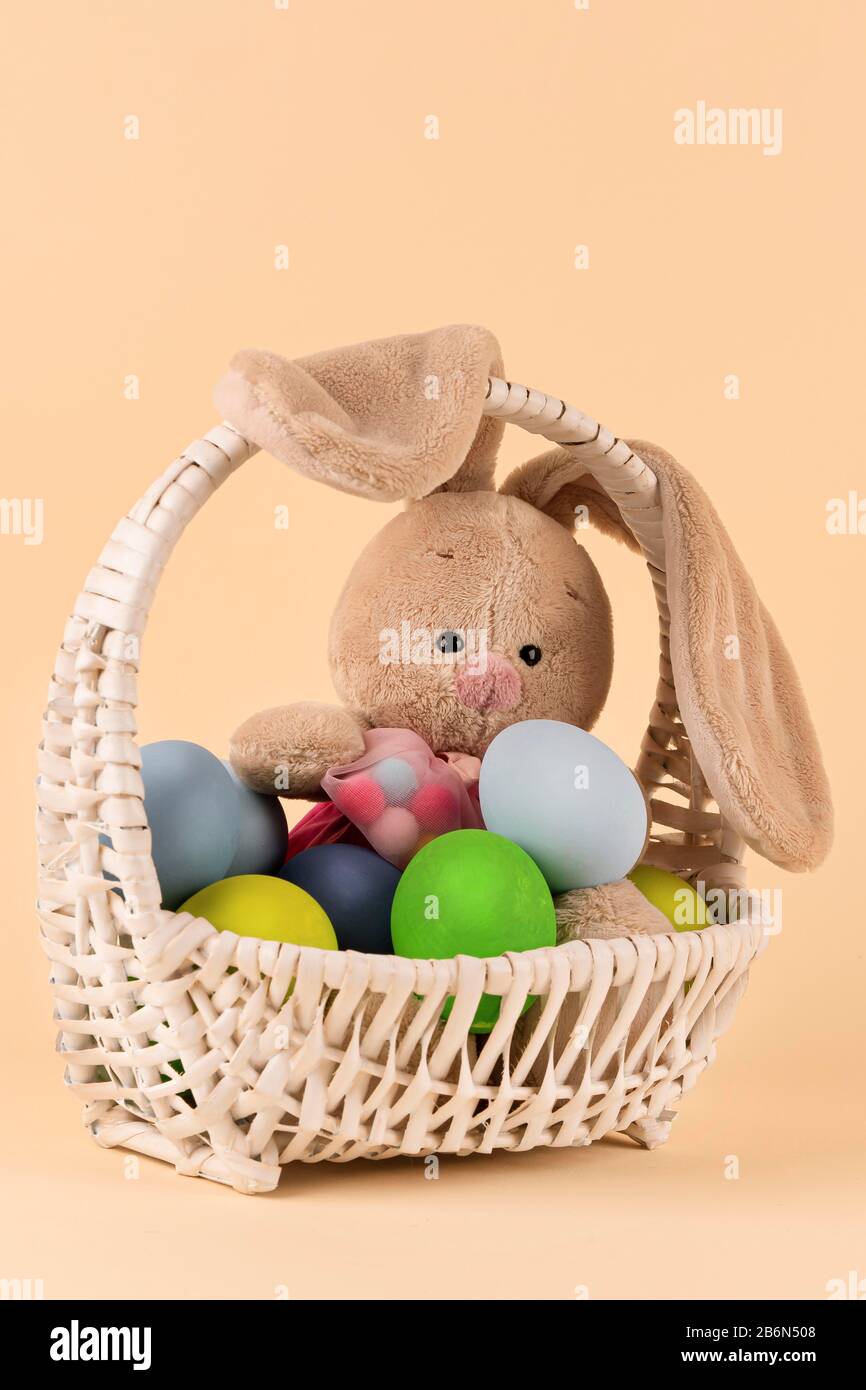 Easter Bunny toy and colorful spring eggs in a basket as a cute gift ...