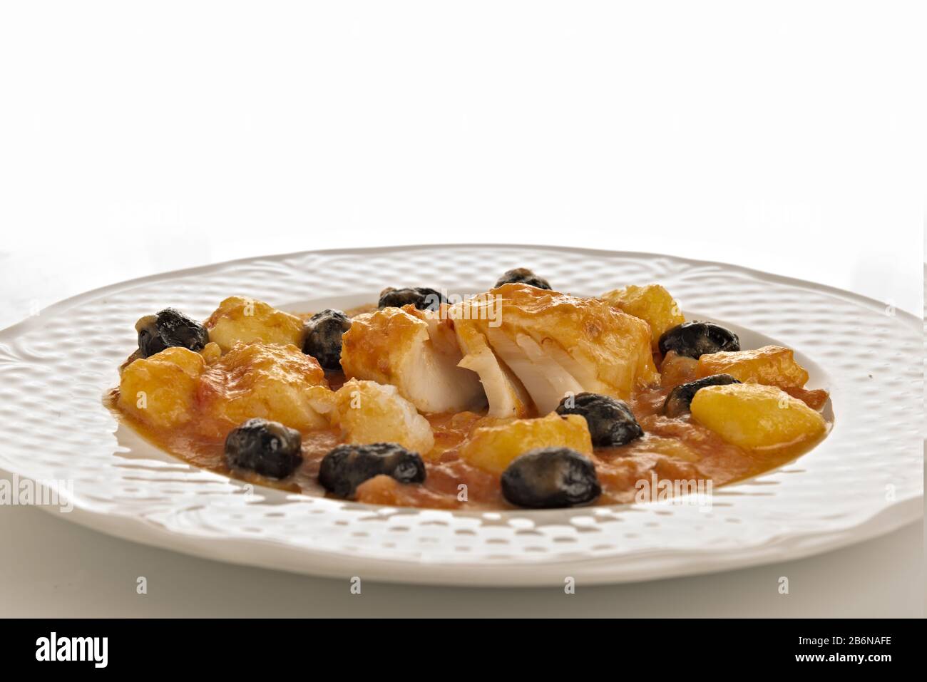 merluzzo al pomodoro con patate e olive nere pezzi rotti Stock Photo - Alamy