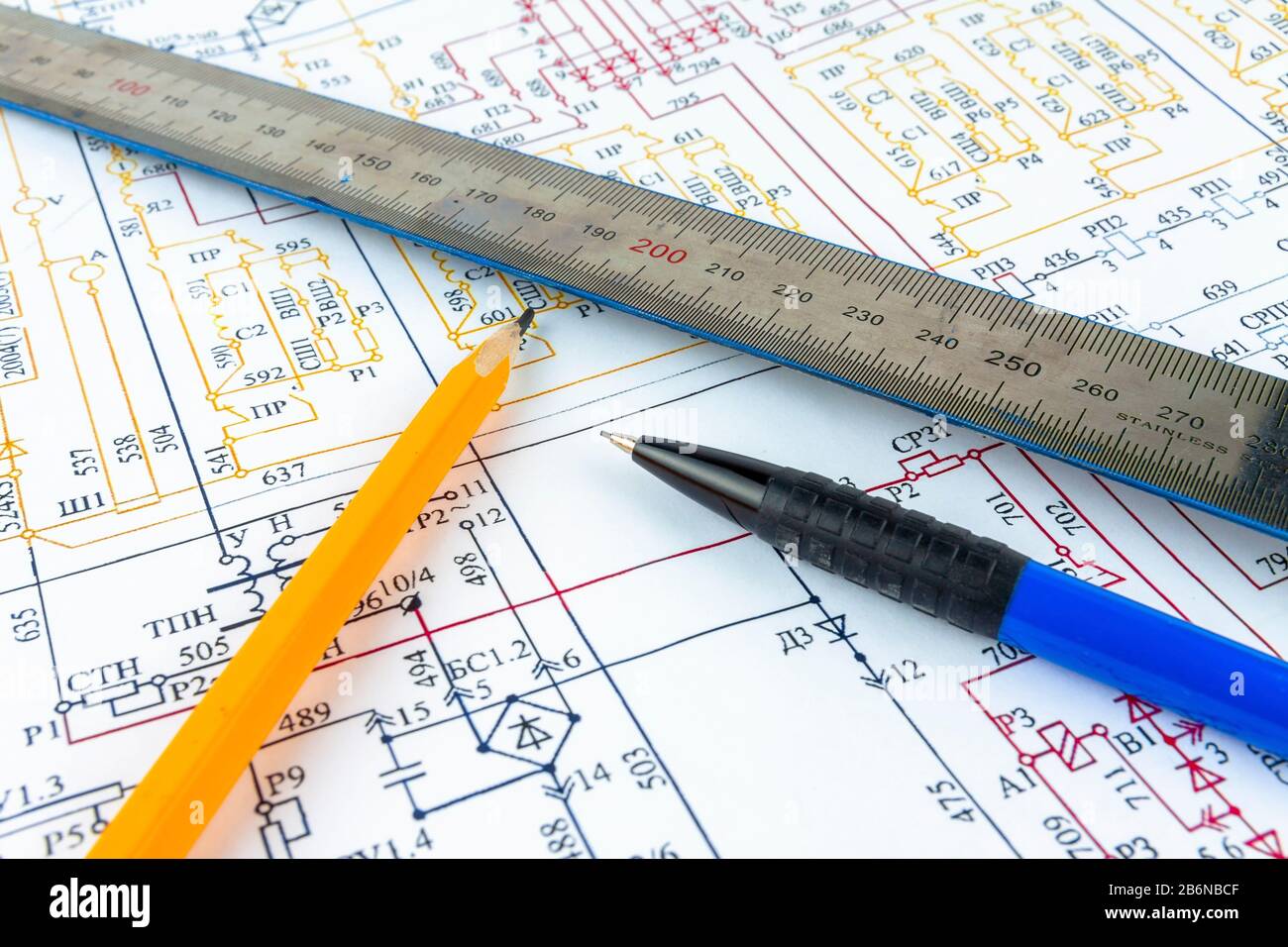 Pencils and a ruler lie on an electric circuit. Stock Photo