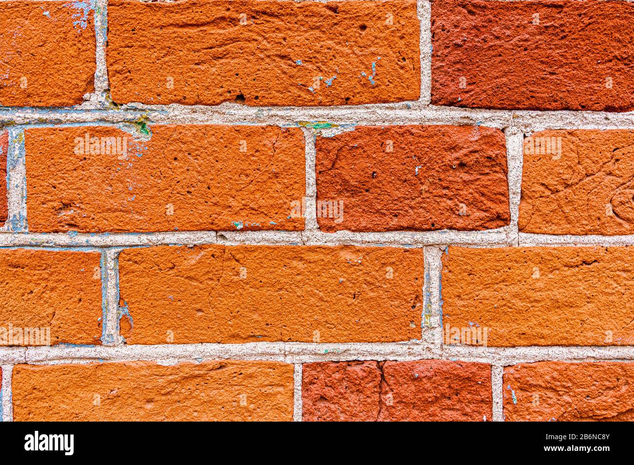 An old weathered fragment of a brick wall with cracks. Background for