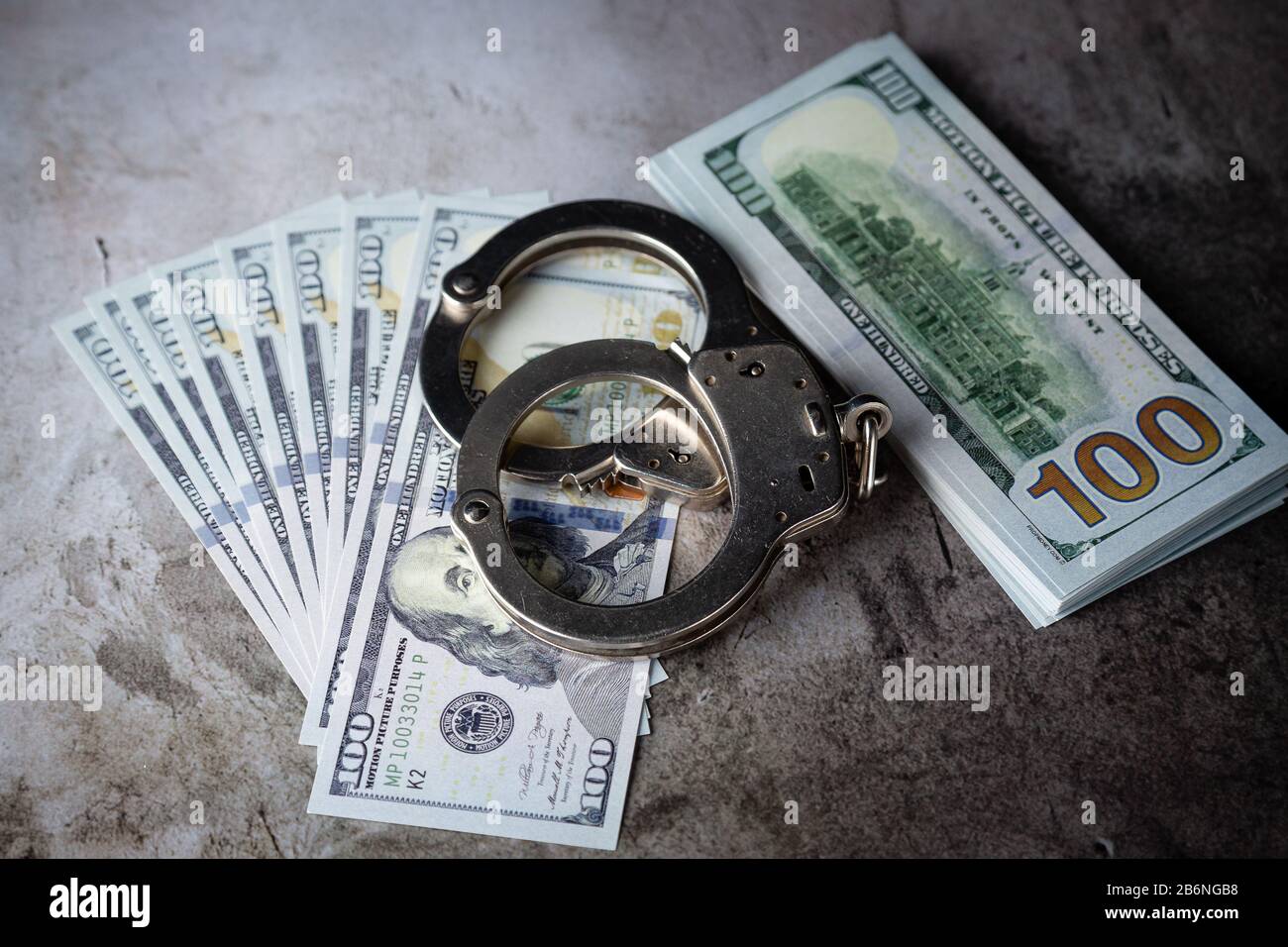 Handcuffs on $100 Bills on Concrete Floor for Crime or DUI Stock Photo