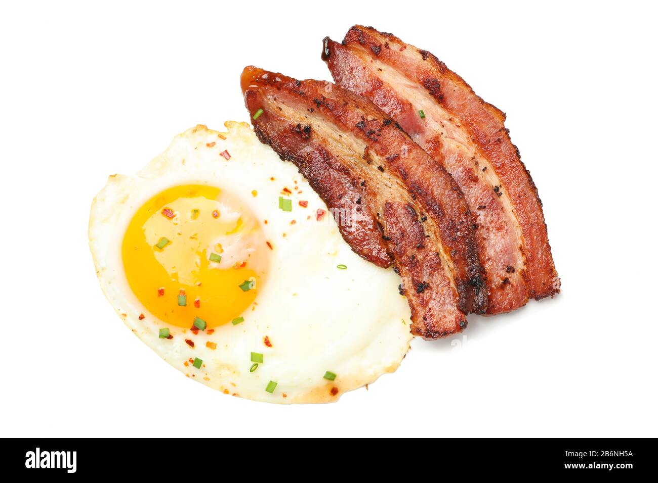 Fried eggs and bacon with spices isolated on white background Stock ...