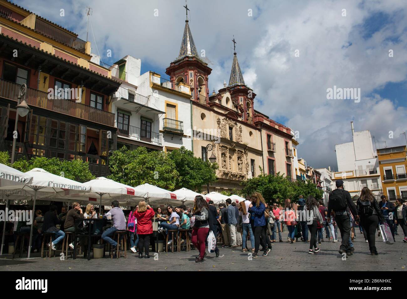 Crowded bar terraces in front of Nuestra Señora de la Paz Hospital in Salvador Square, Seville, Spain Stock Photo