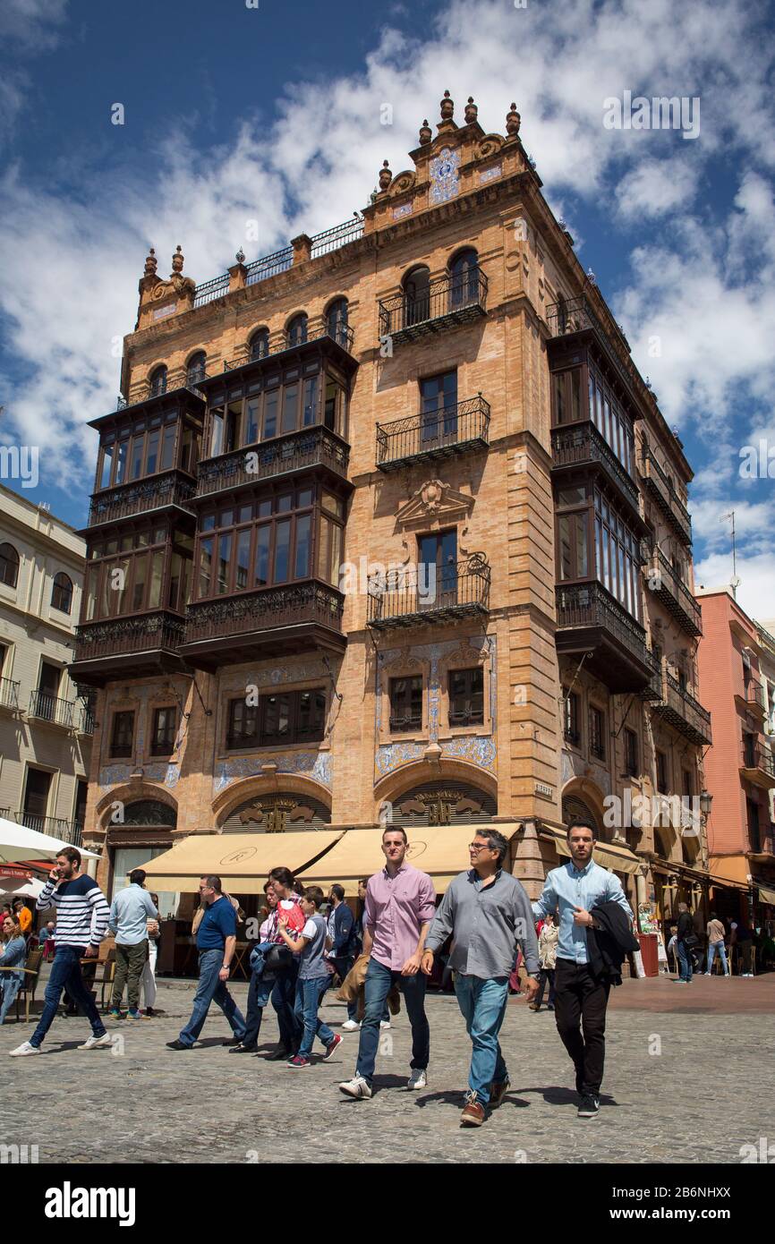 Vertical shot of some passersby in front of the Laredo building at the corner of Sierpes St with San Francisco Square, Seville, Spain Stock Photo