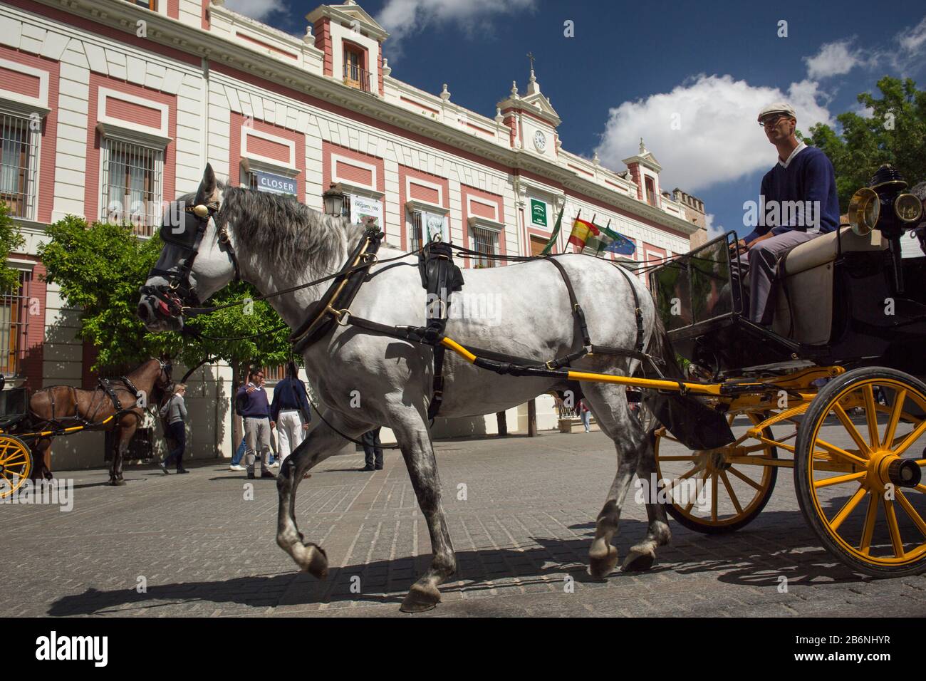 Close-up photograph of a moving horse carriage next to Provincia’s House at Triunfo Square, Seville, Spain Stock Photo