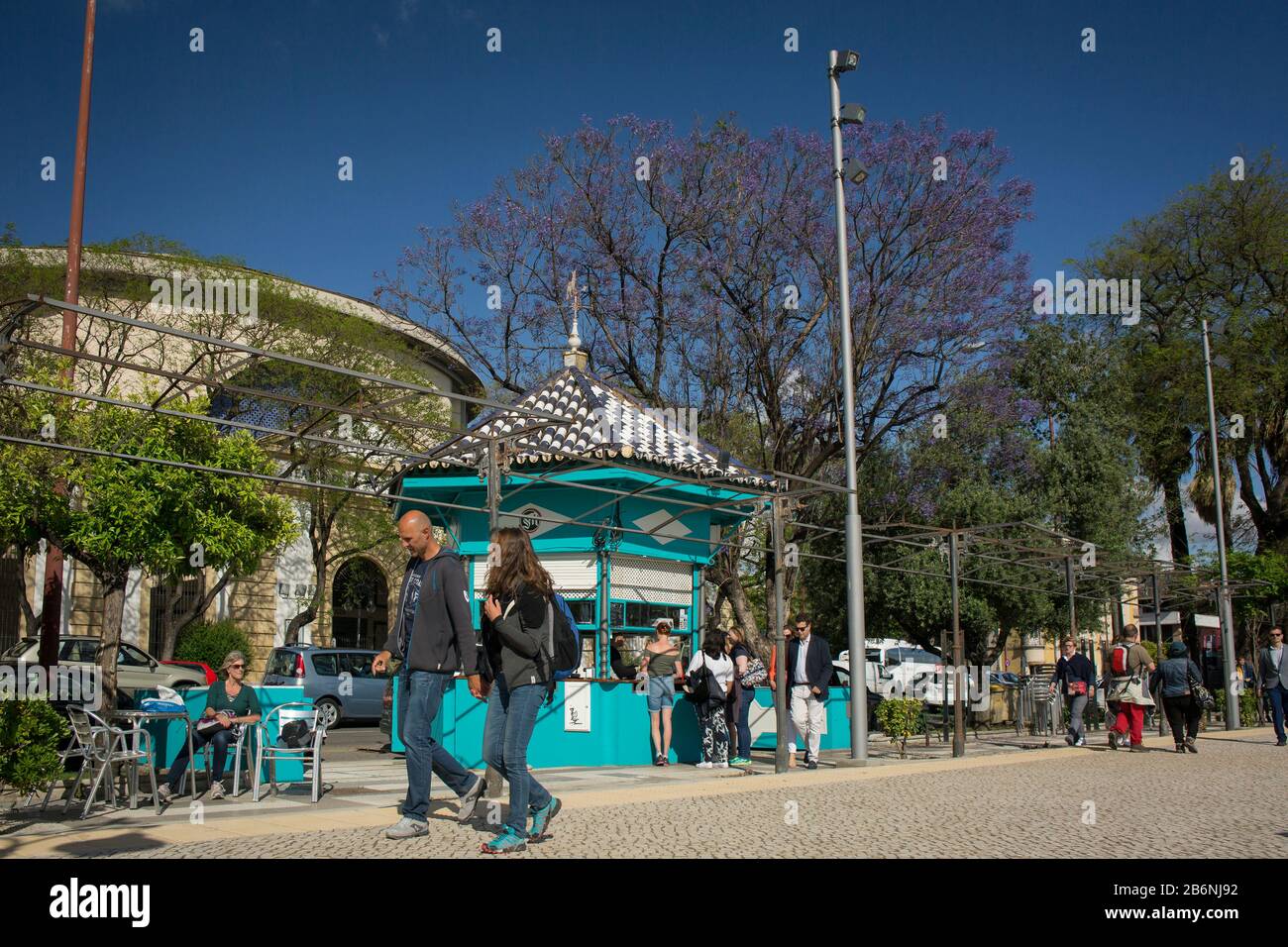 Passersby and kiosk with terrace at Cristobal Colon Walk on a spring and sunny day, Seville, Spain Stock Photo