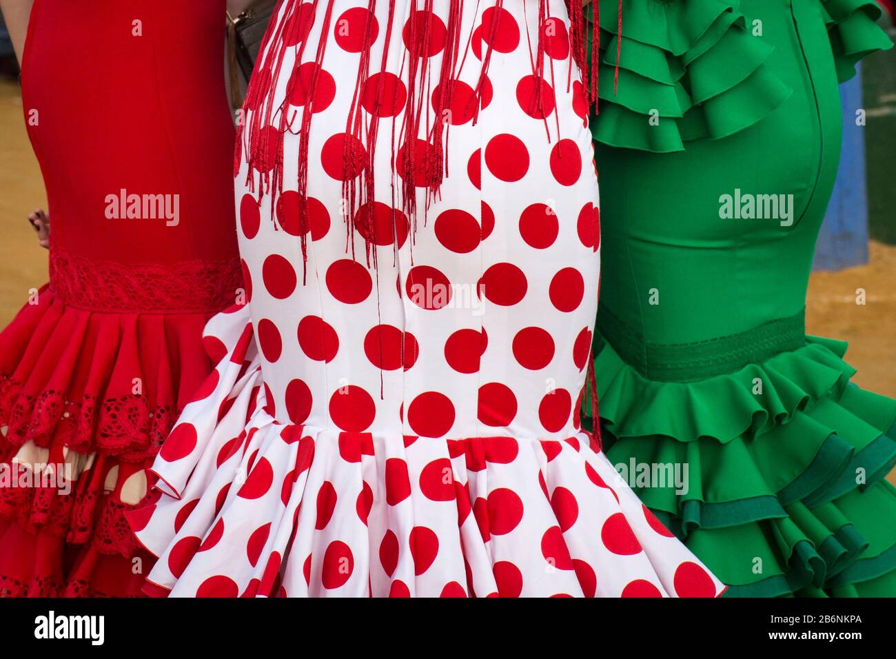 Pencil skirts of three Sevillian costumes, photographed from the back, in the Feria de Abril, Seville, Spain Stock Photo