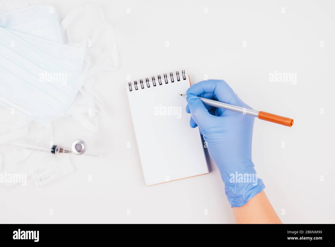 A gloved hand, medications, a syringe, and masks. Stock Photo