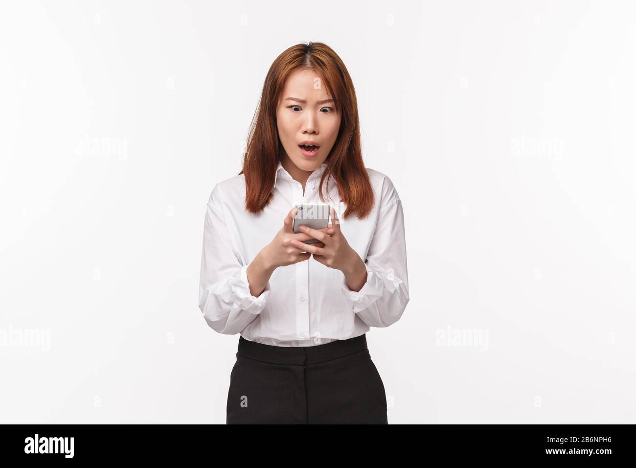 Portrait Of Shocked And Speechless Asian Woman Staring At Smartphone