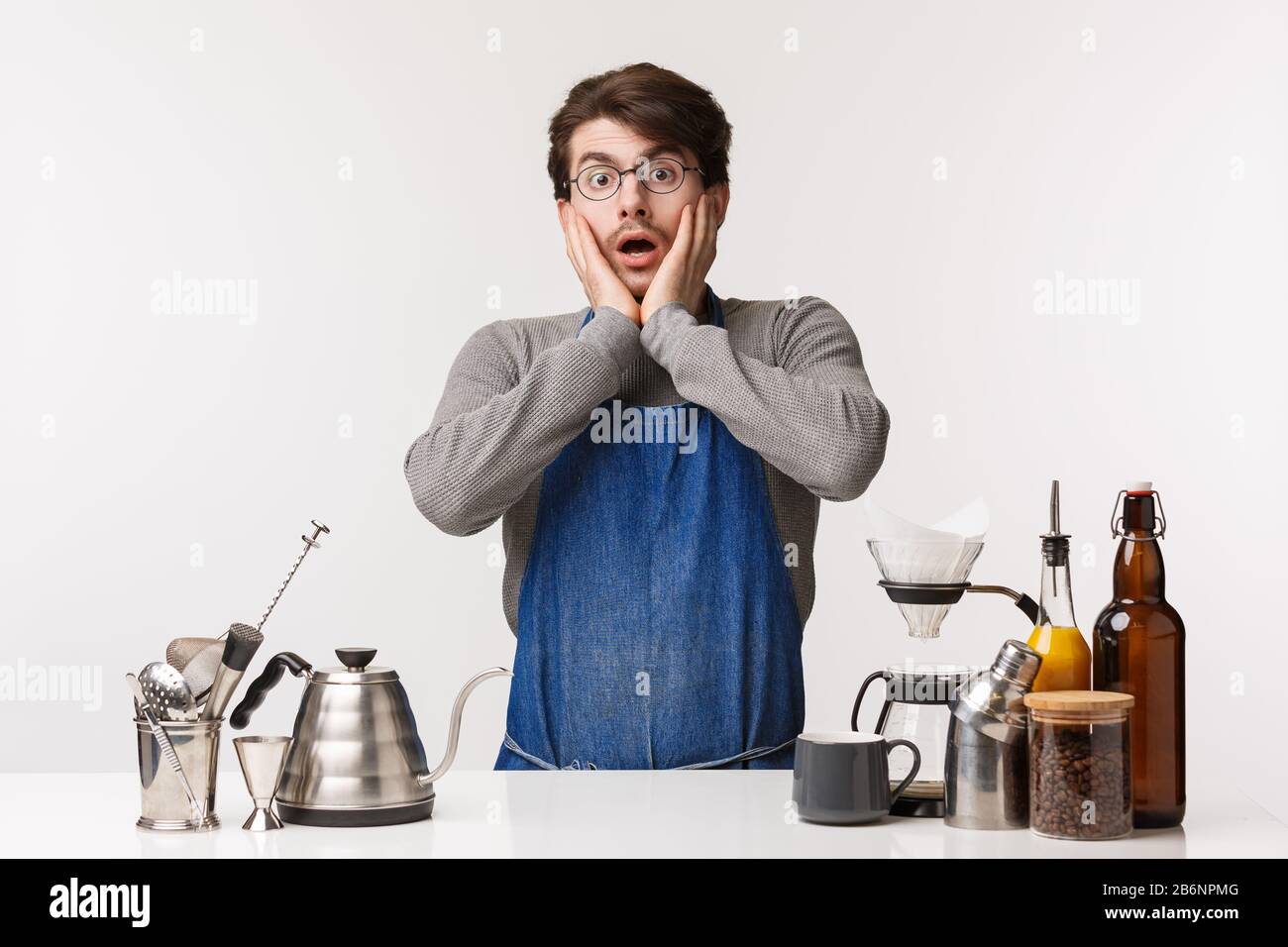 Barista, cafe worker and bartender concept. Shocked speechless young caucasian guy in apron