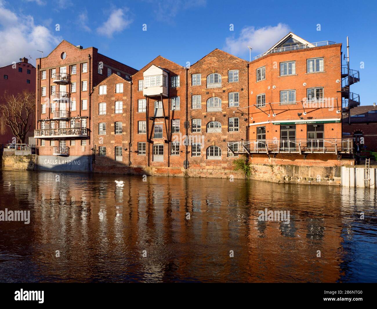 River frontage of former Fletland Mills converted warehouse buildings by the River Aire at Calls Landing in Leeds West Yorkshire England Stock Photo