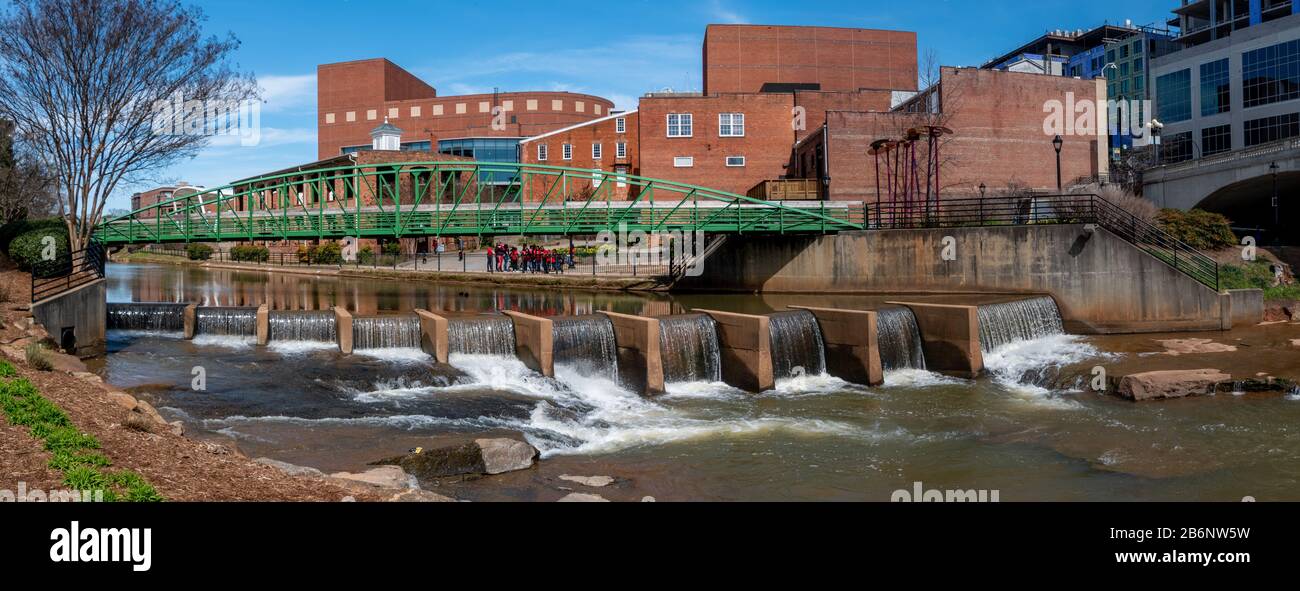 A panoramic view of a pedestrian bridge and a dam on the Reedy River in downtown Greenville, South Carolina Stock Photo