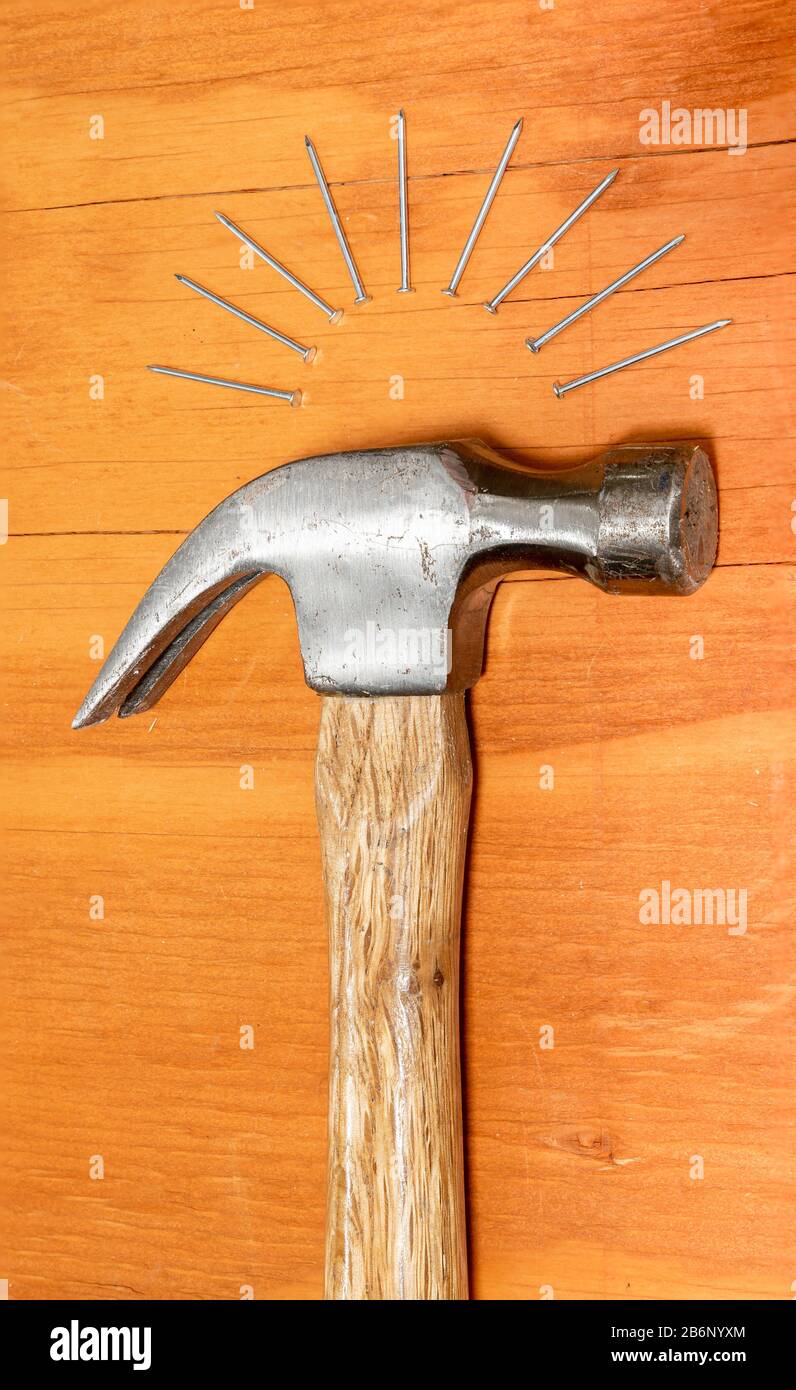 A hammer and metal nails on a stained wooden background Stock Photo