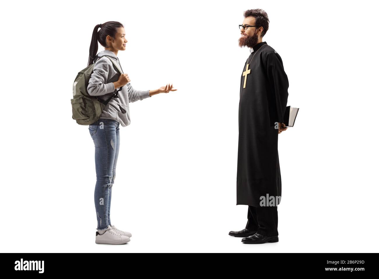 Full length profile shot of a female student talking to a priest isolated on white background Stock Photo