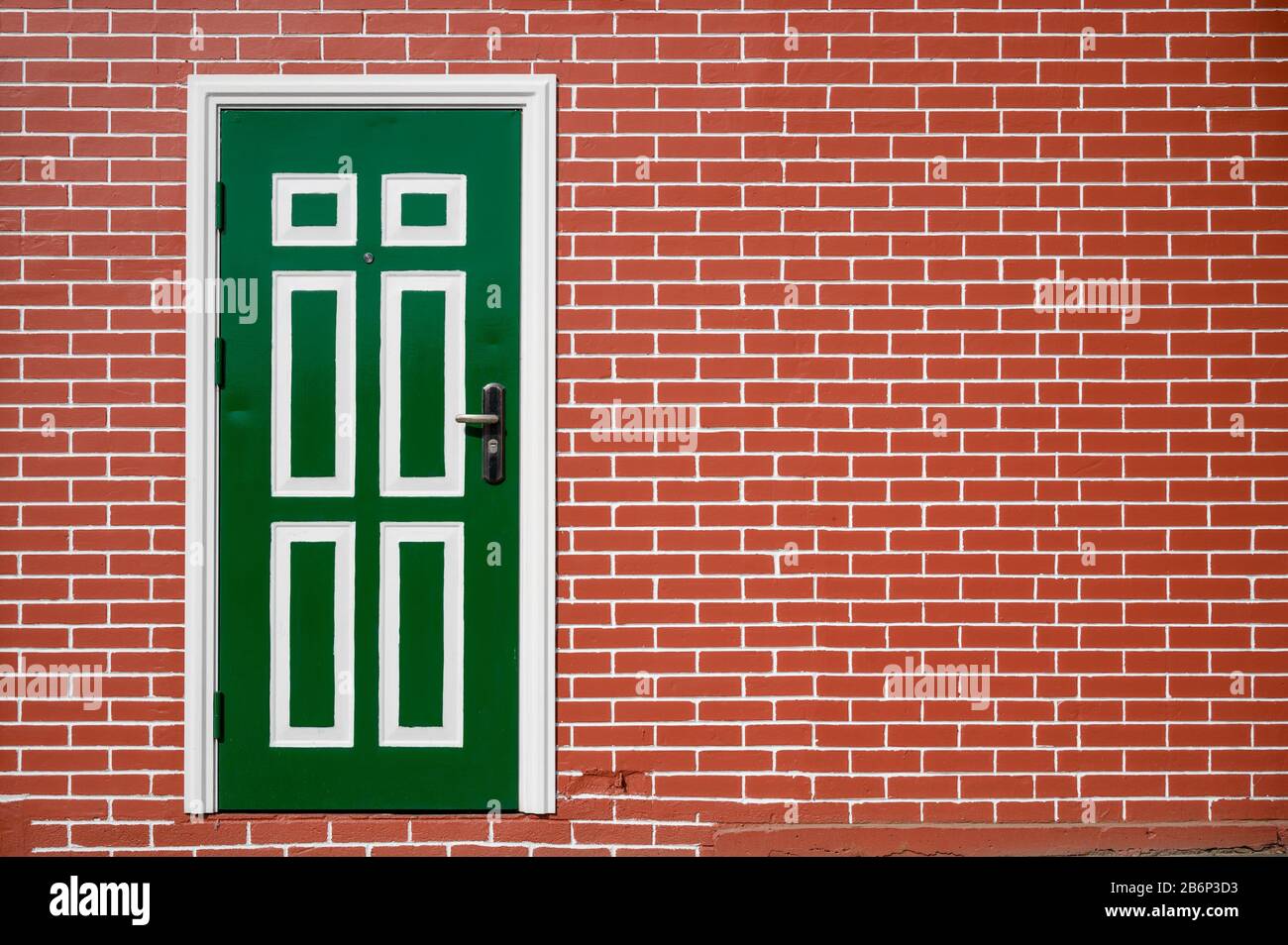 Regular brick wall with white grouting surrounding a green door with
