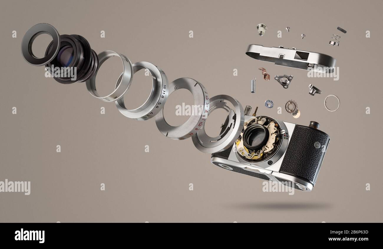 disassembled camera with pieces that jump, photomontage, with clear background and retro camera Stock Photo