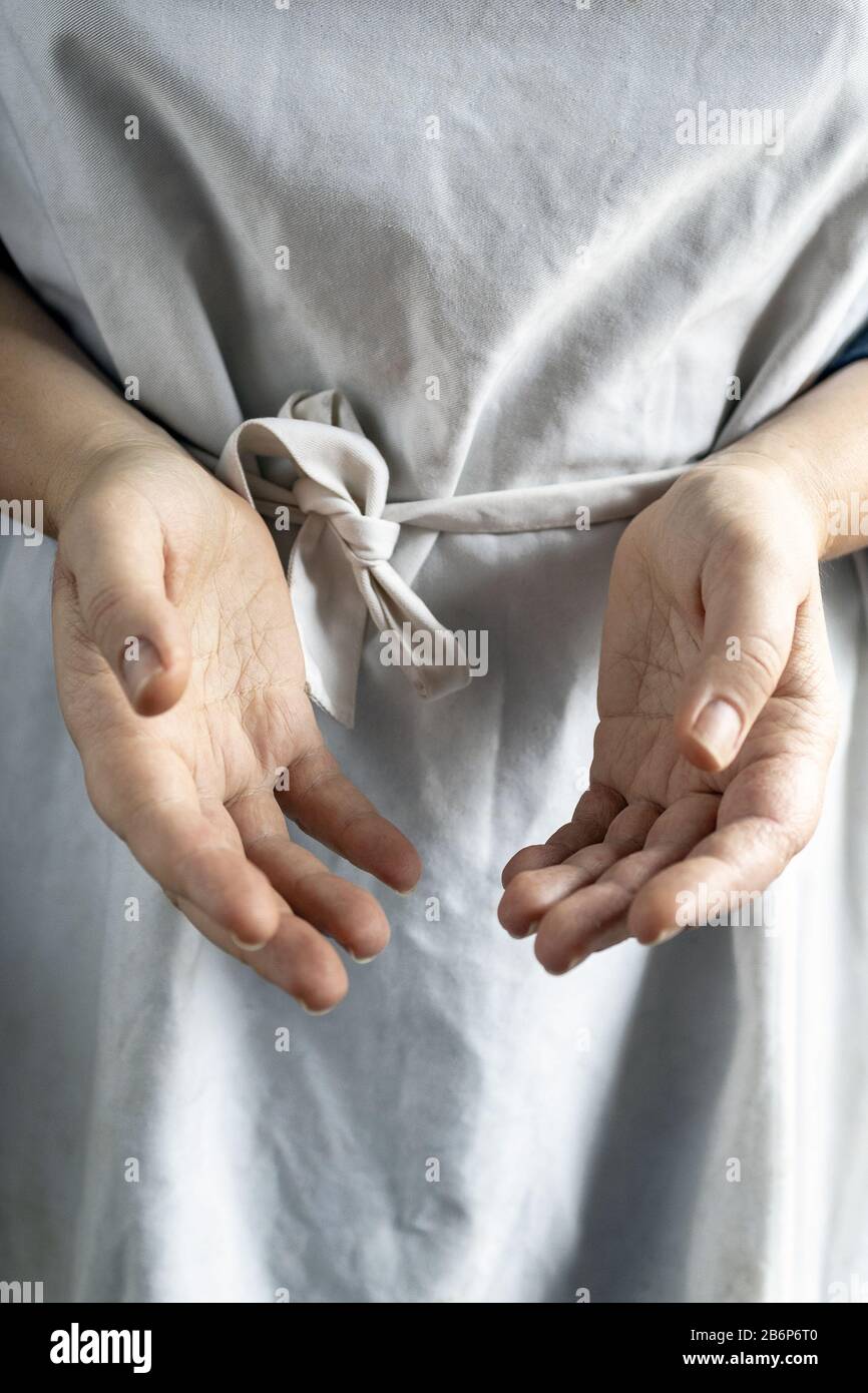 female hands in a white cook apron hold the void. Copy space, close-up. Film tinting Stock Photo