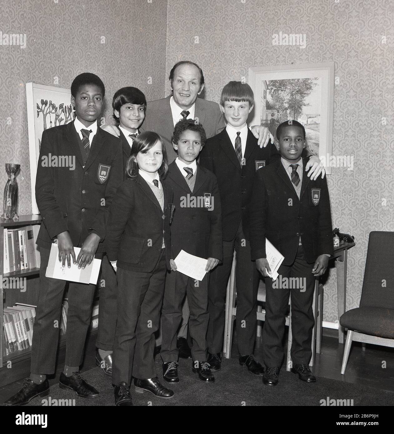 1972, historical, Legendary British heavyweight boxer Henry Cooper posing for a picture with a group of schoolboys on a visit to an inner city secondary school in Catford, South east London, England, UK. Stock Photo