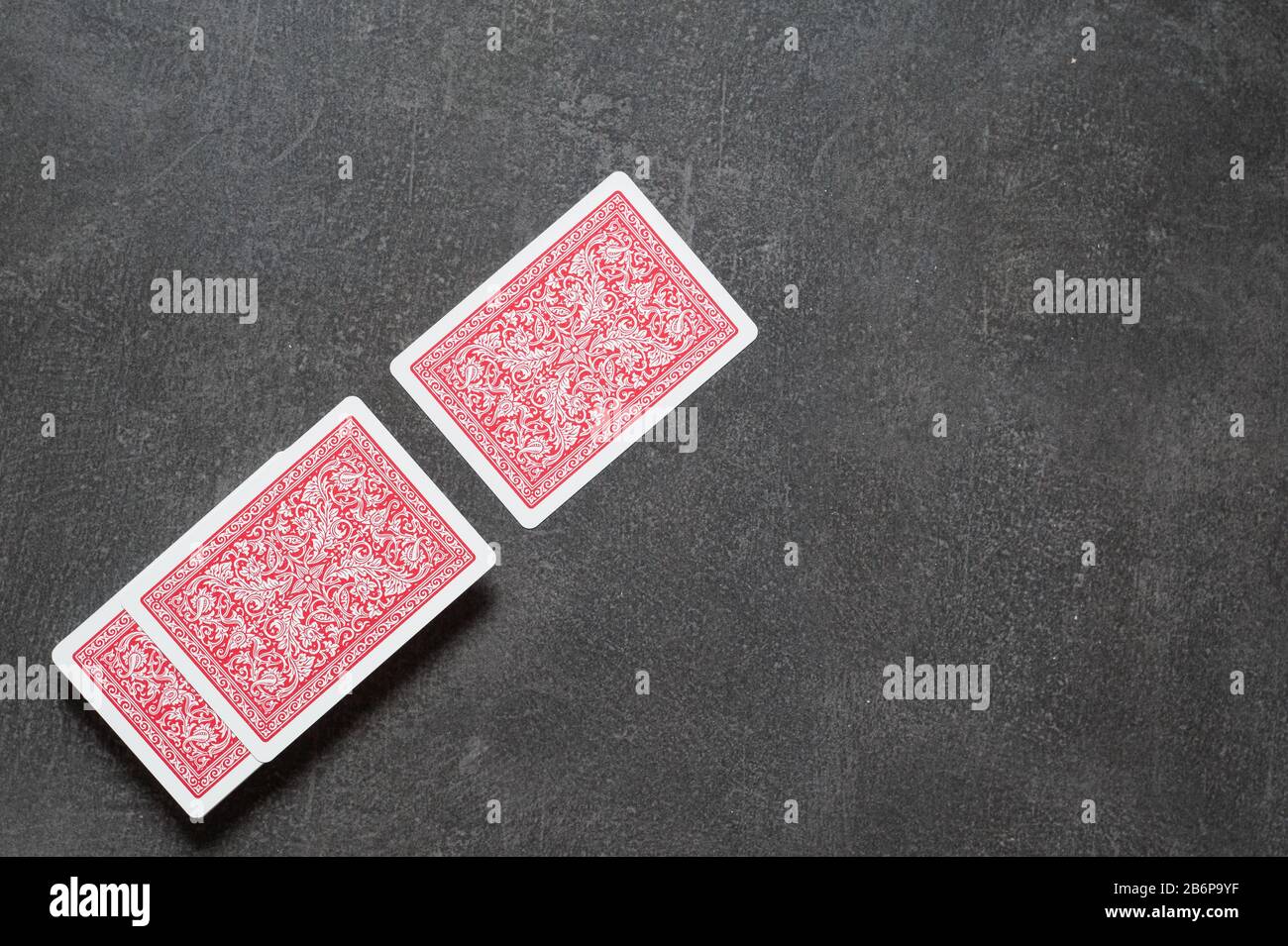 Deck of playing cards and one card separately face down on a black