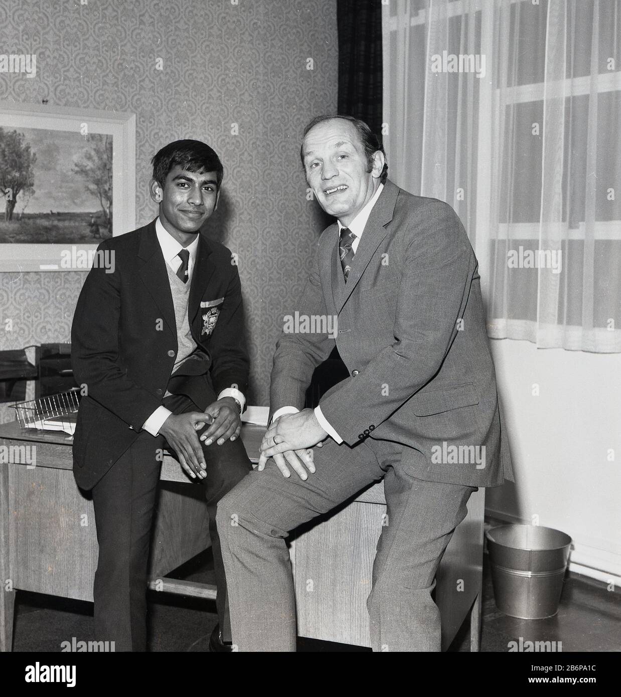 1972, historical, Legendary British heavyweight boxer Henry Cooper posing for a picture with a pupil on a visit to a secondary school in Catford, South east London, England. A popular sportsman, Cooper who was a Londoner, born in Lambeth, was the first person to twice win the BBC Sports Personality of the Year Award. He is also the only boxer to have been awarded a knighthood. Stock Photo