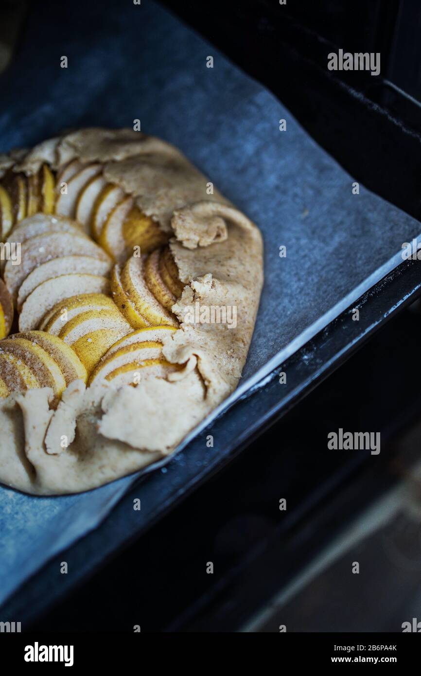 Raw apple galette - pie on white baking parchment. Copy space, flat lay. Stock Photo