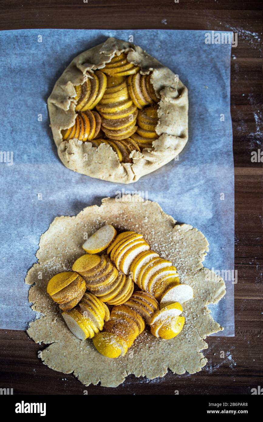 Raw apple galette - pie on white baking parchment. Copy space, flat lay. Stock Photo