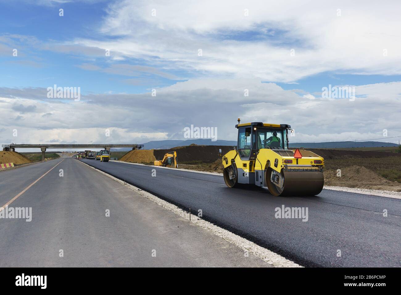 Laying the next layer of asphalt in the construction of a new road Tavrida in the Crimea. The crossing of roads is equipped with safe bridge crossings Stock Photo