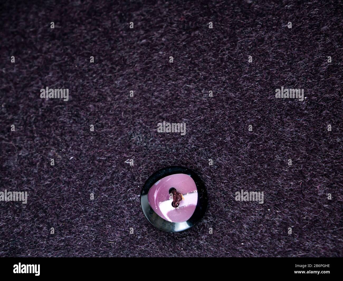 Colored button on a woolen cloth coat. Stock Photo