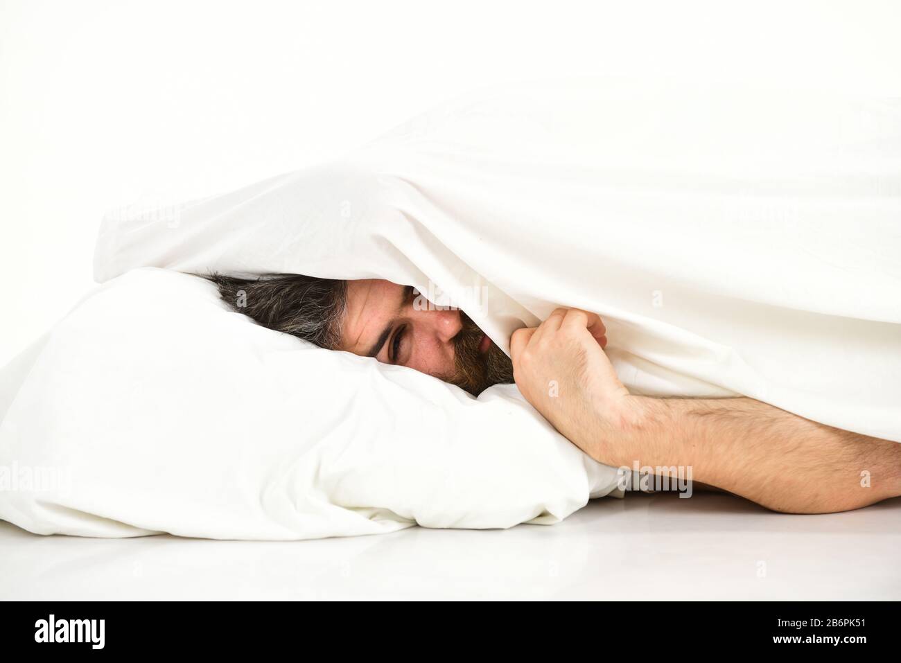 Rest and silence concept. Man with drowsy face lies on pillow