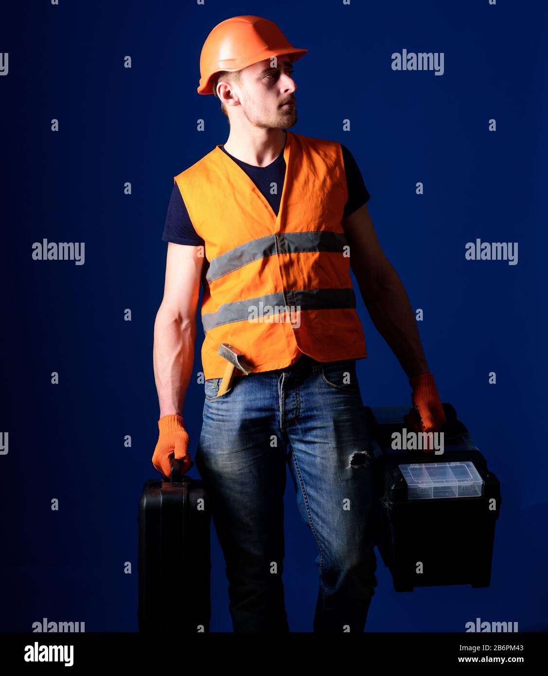 Man in helmet, hard hat holds toolbox 