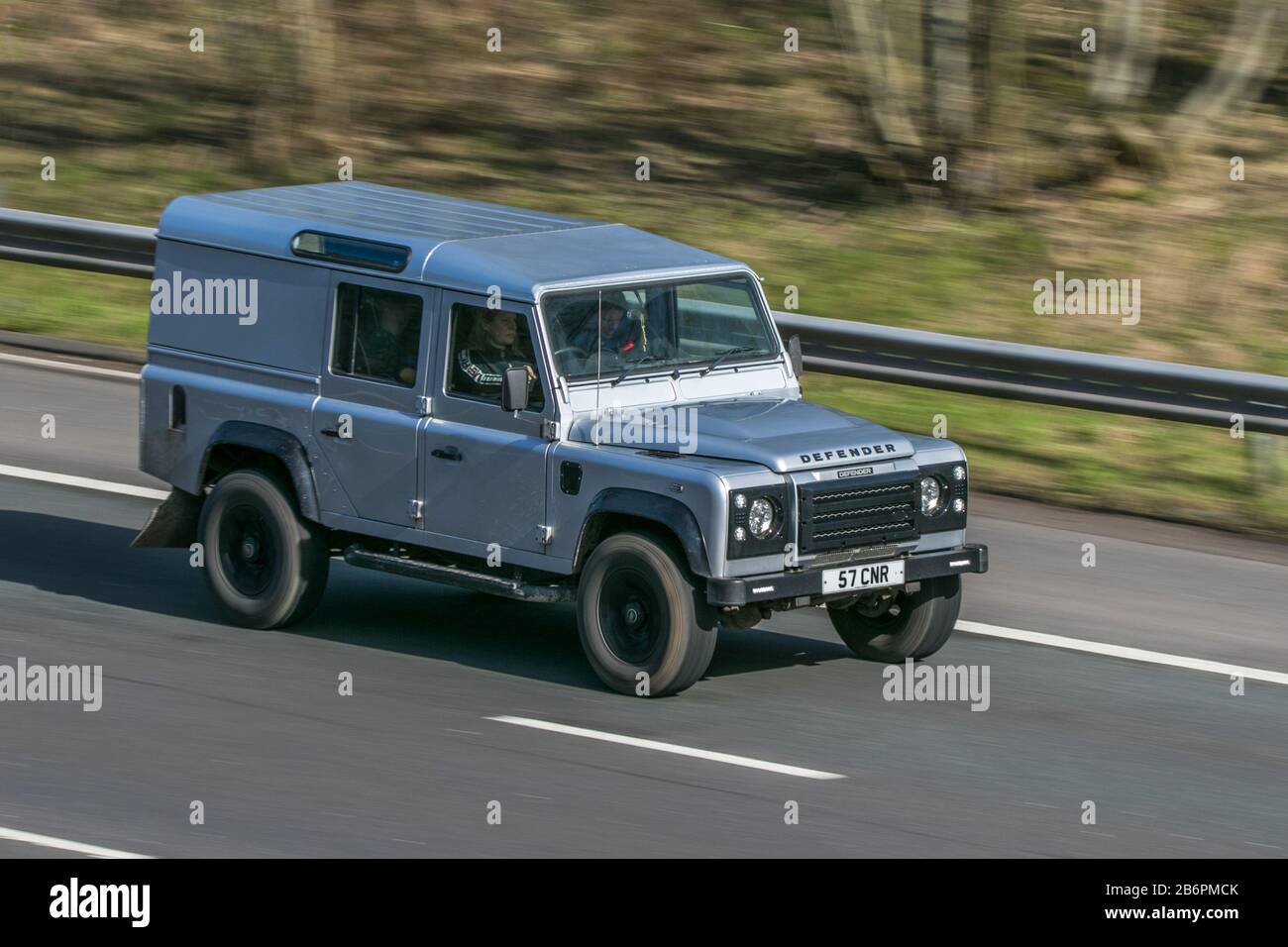 Silver land rover defender driving hi-res stock photography and