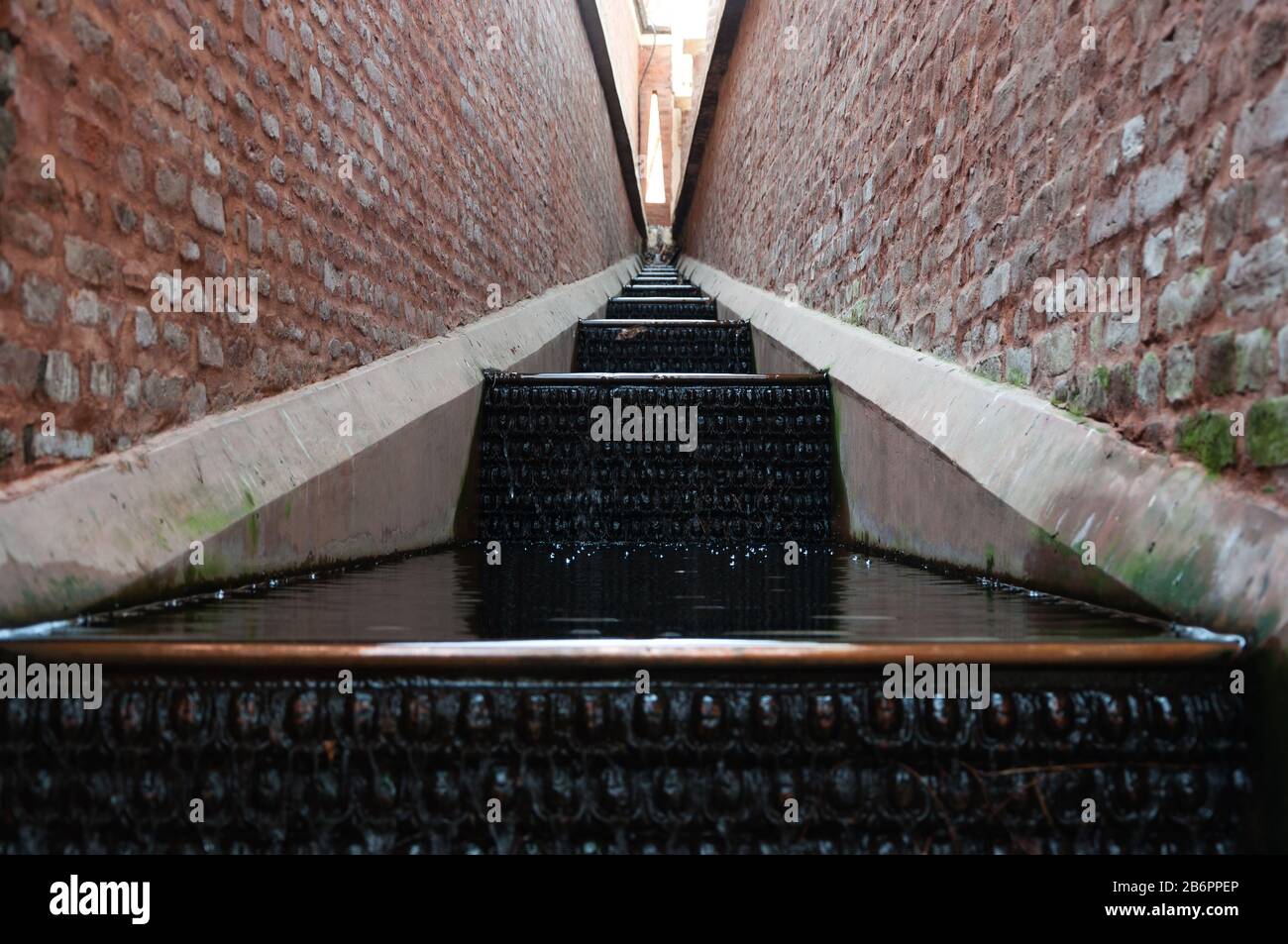 Still waterfall within brick walls Stock Photo Alamy