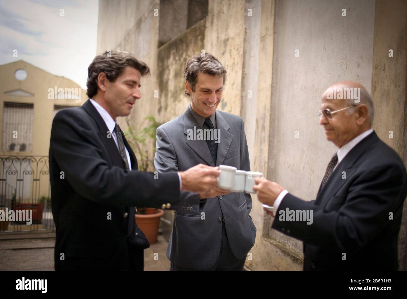 View of three men having a conversation over a cup of drink. Stock Photo
