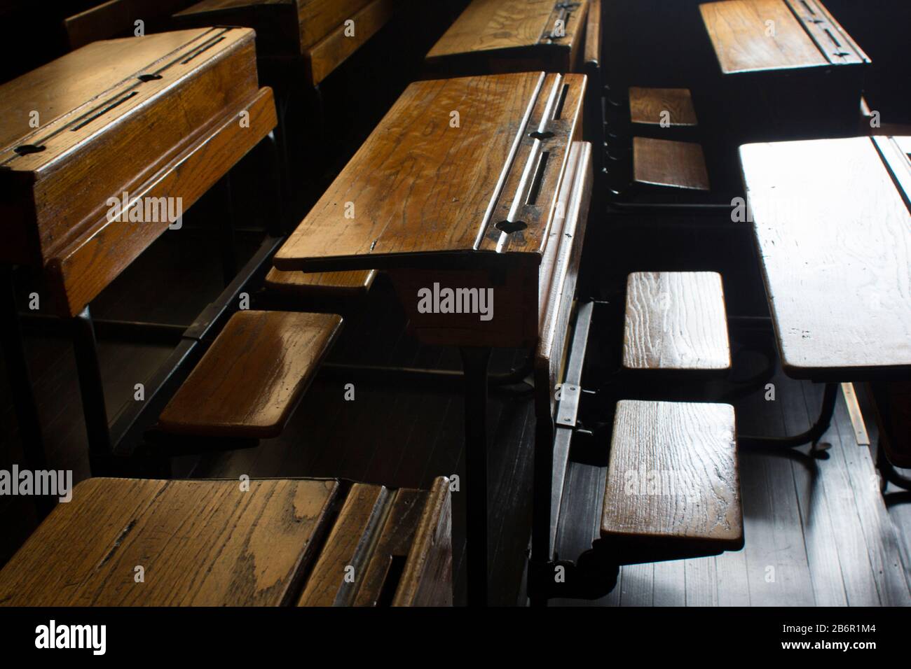 Rows Of Old Fashioned School Desks In A Classroom In Day Light
