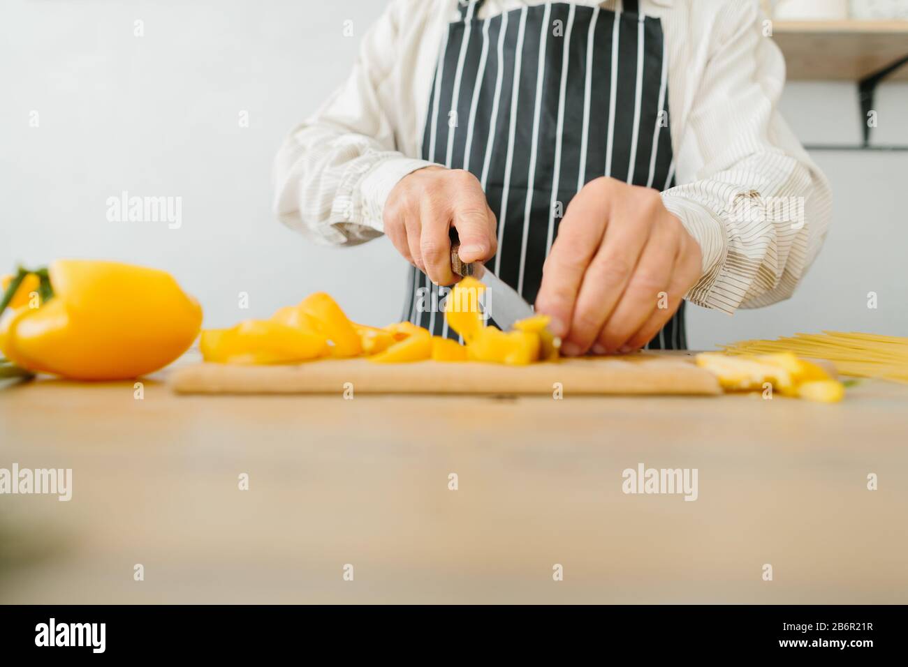 senior father prepares a salad in the kitchen Stock Photo