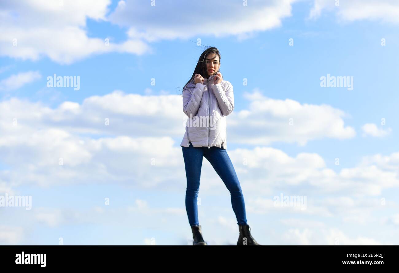 girl wear jacket in city street. Stylish fashion model outdoor. People freedom style. Winter Warm Clothing. girl wearing casual jeans clothes. enjoys sunny day and blue sky. beauty and fashion. Stock Photo