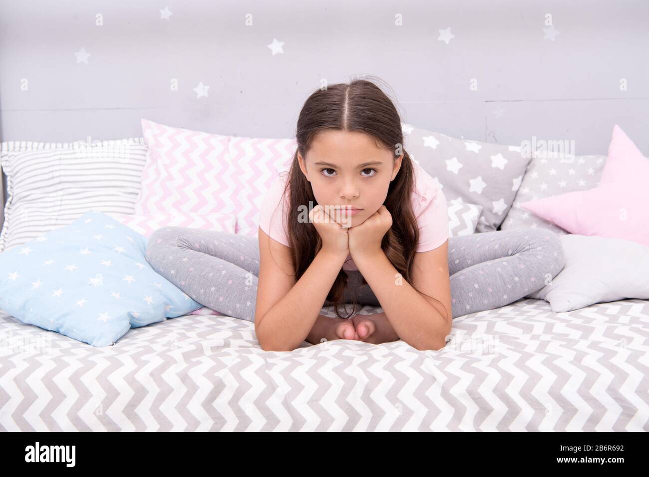 Why so sad. Sad girl sit in bed. Little child with sad look. Bedtime routine. Daytime nap. Kids health. Childcare. Early morning hour. Good night. Unhappy and sad. Stock Photo