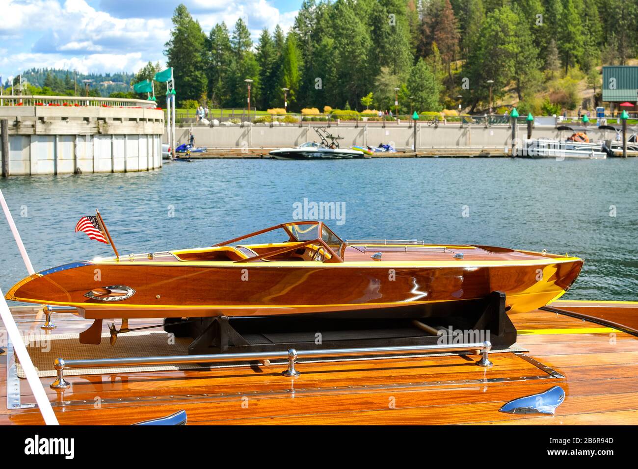 A miniature wooden boat sits atop a lifesize wooden boat at the