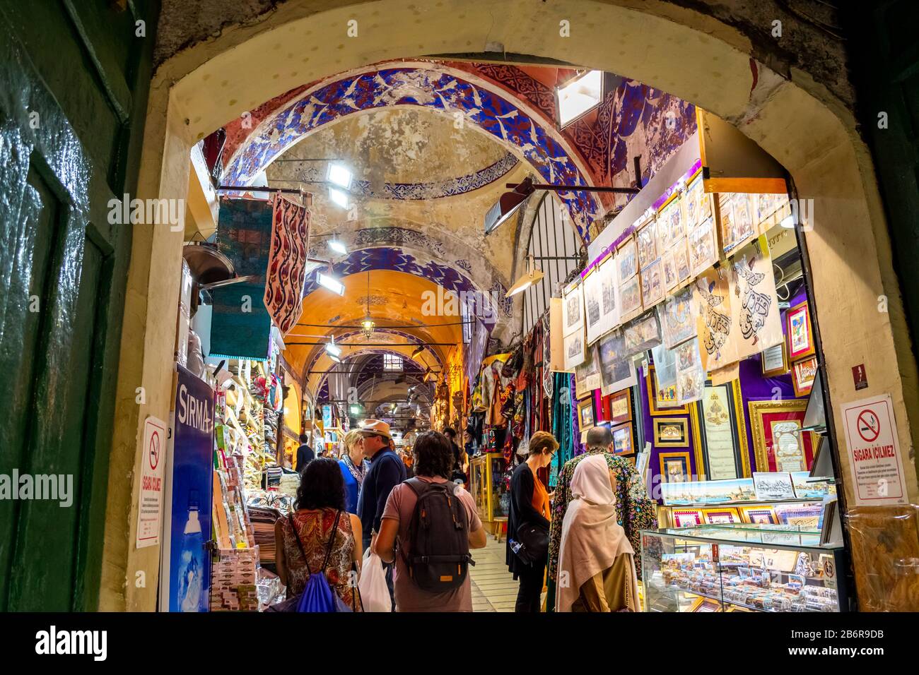Tourists shop the souvenirs, textiles and gifts in the colorful, historic indoor Grand Bazaar in Istanbul. Stock Photo