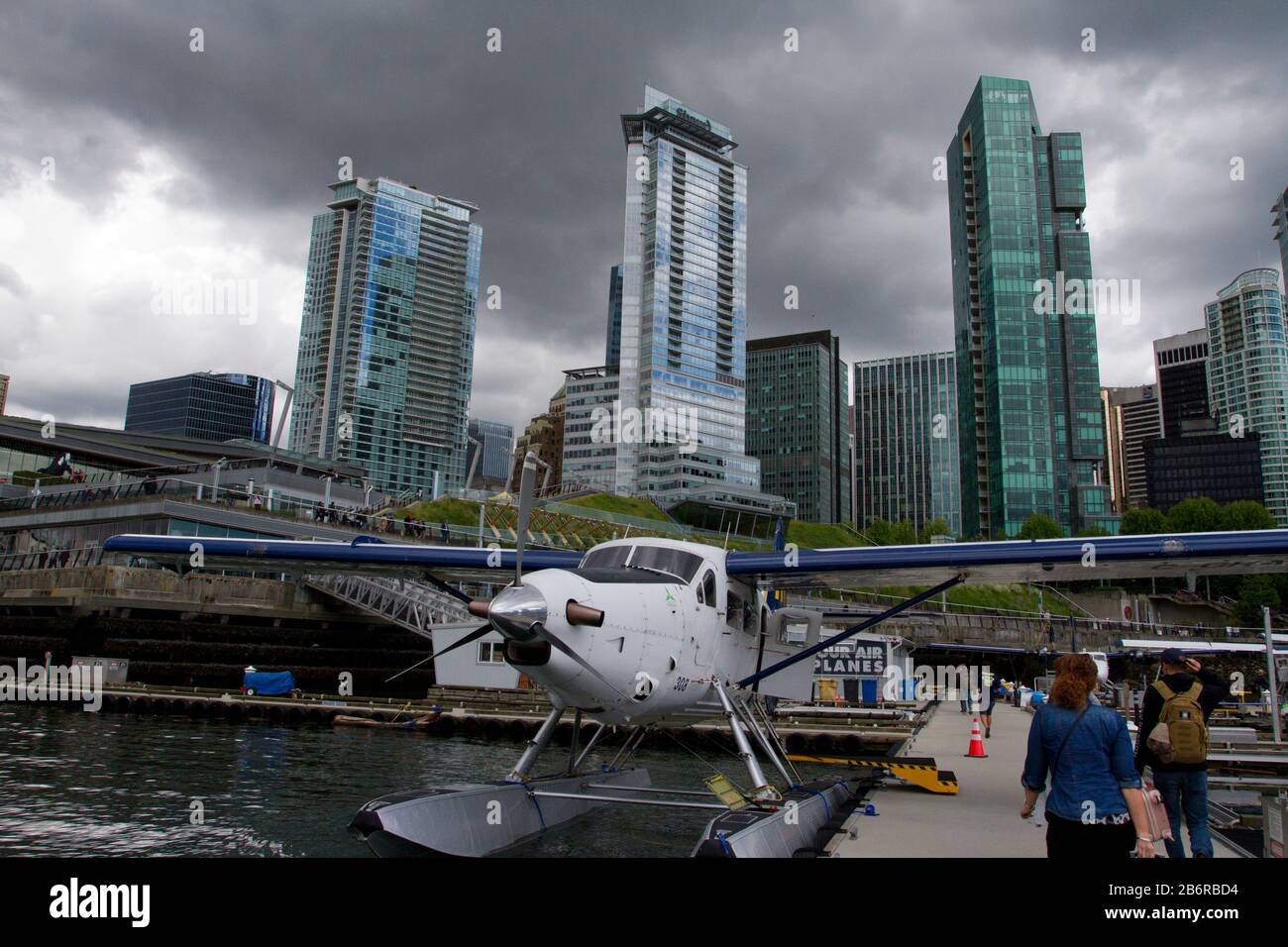 A Harbour Air DHC-3 de Havilland Turbine Single Otter seaplane at Coal Harbour, Vancouver, BC, Canada with skyscrapers and a stormy sky in background Stock Photo