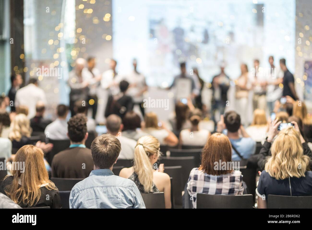 Young business team receiving award at best business project competition event. Stock Photo