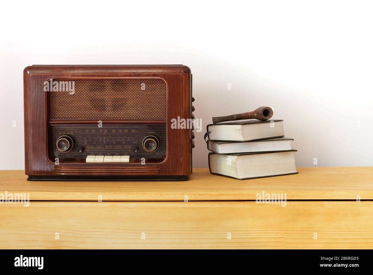 Vintage radio made of wood, old books and a pipe on a table Stock Photo -  Alamy