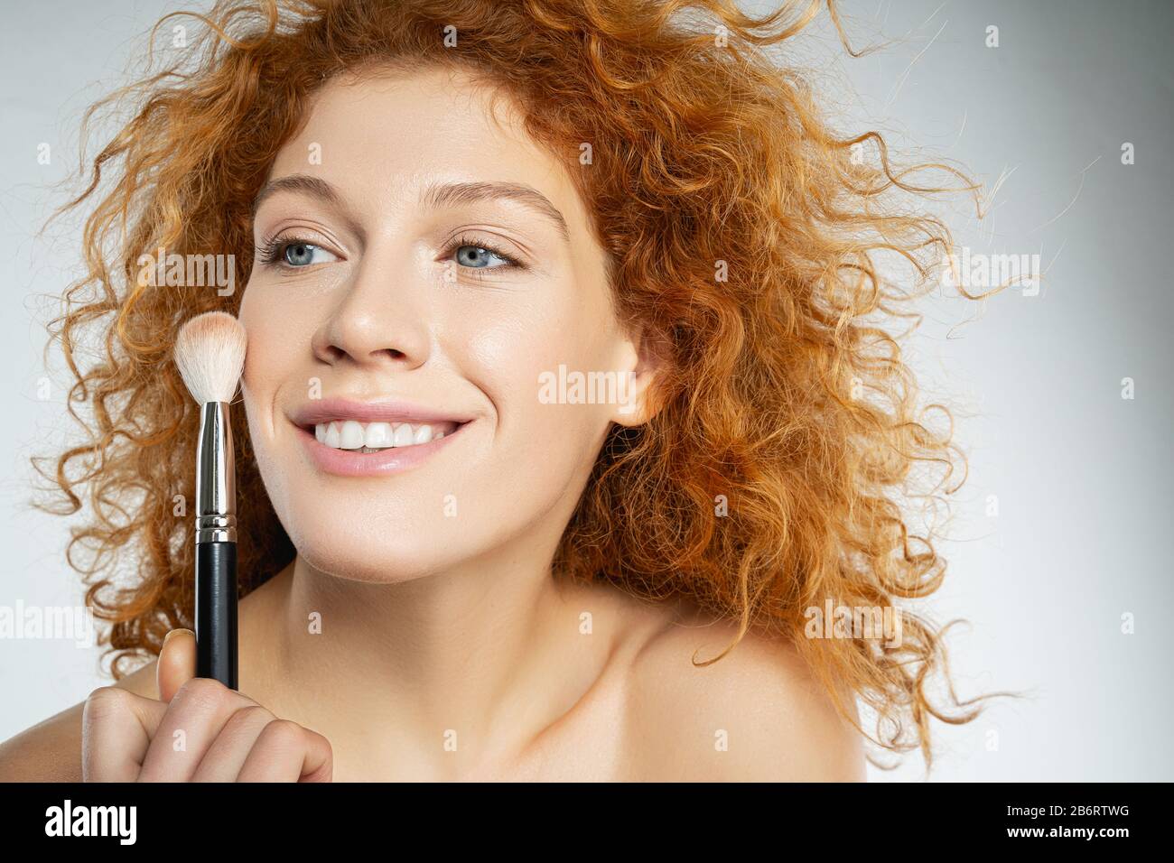 Positive delighted young female person holding brush Stock Photo