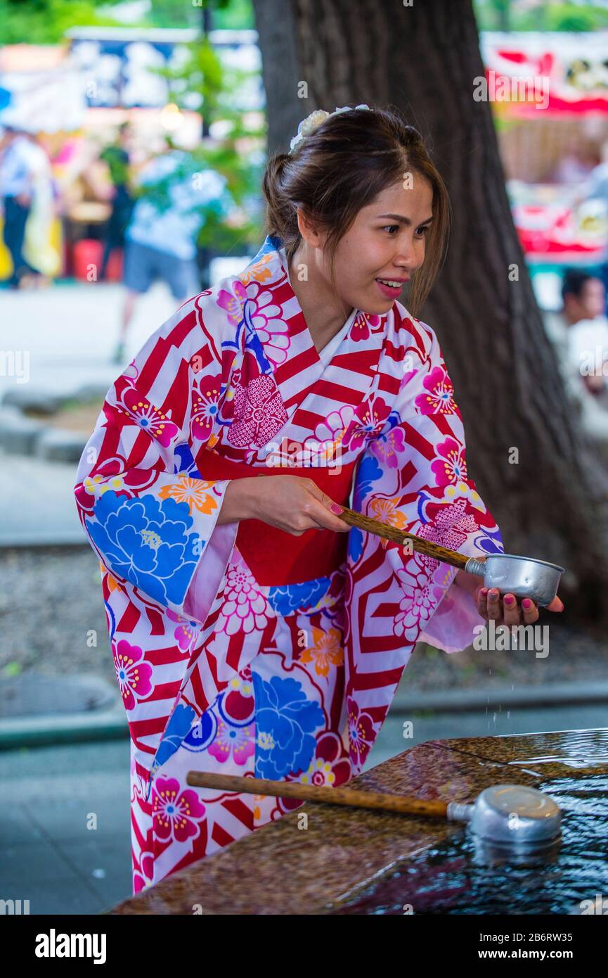 Japanese woman washing hands in a Chozuya in a shrine in Tokyo Japan