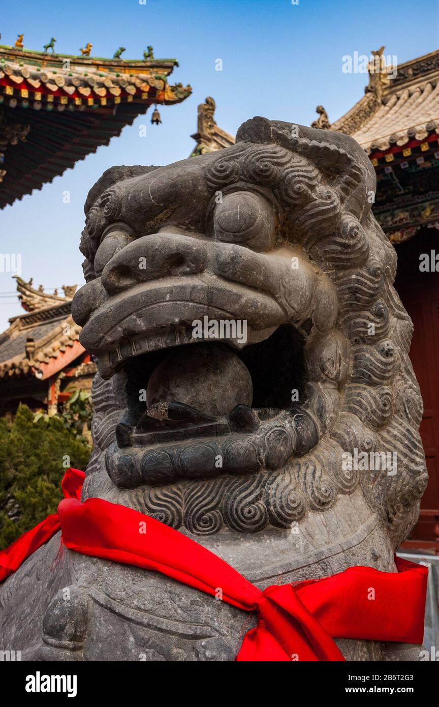 Stone lion in front of buildings at the Shanshangan guild hall in Kaifeng. Kaifeng was the capital of the Northern Song Dynasty. Henan Province, China Stock Photo