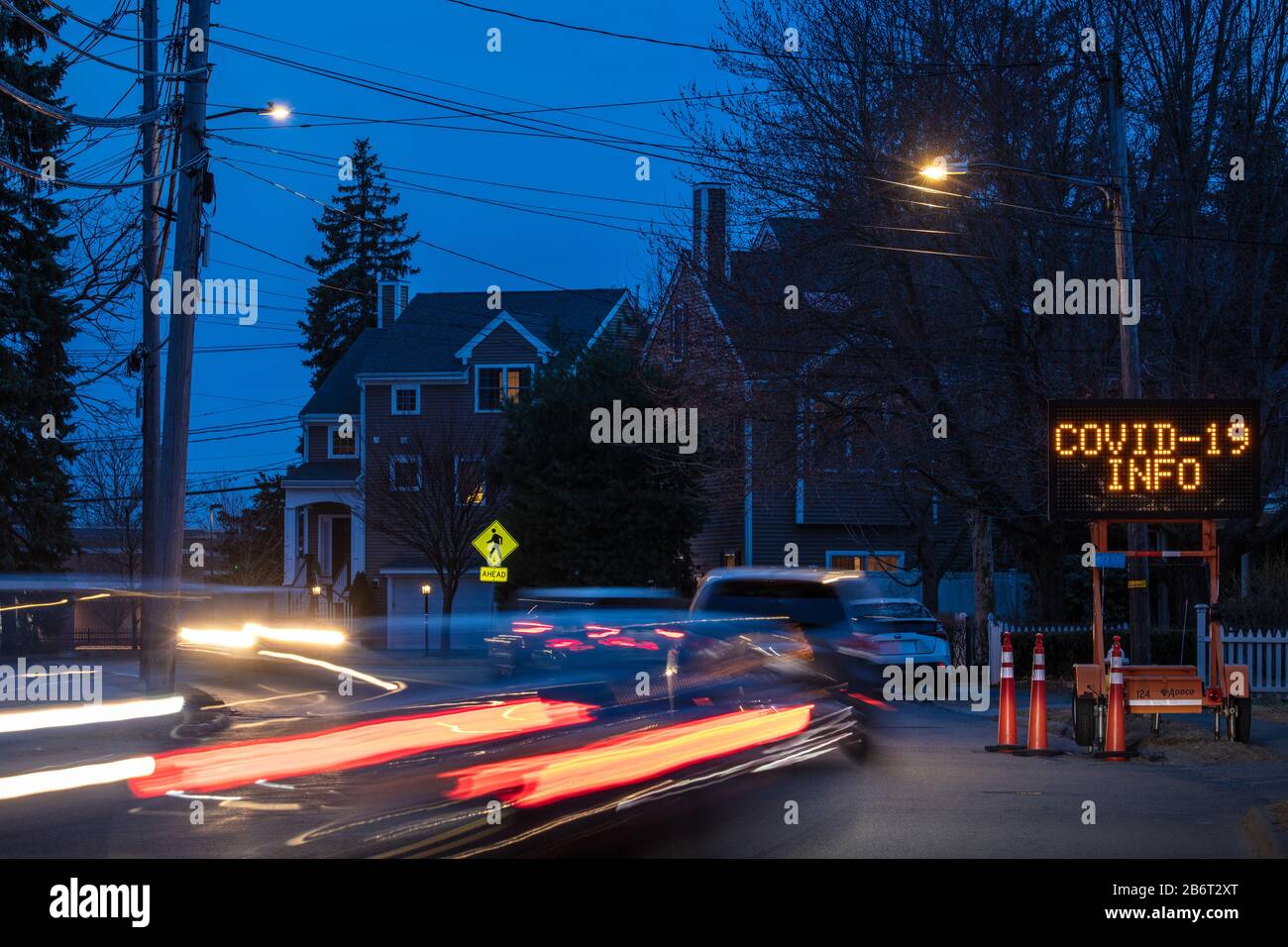 Flashing emergency road sign with COVID19 info and automobile traffic on Highland Avenue at